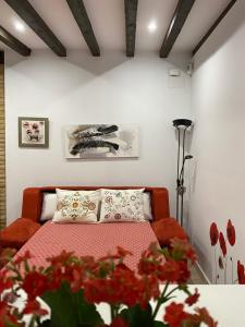 1 dormitorio con 1 cama con flores rojas en Don Quijote, en Toledo