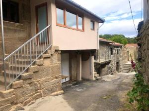 a house with a staircase on the side of it at Apartamento rural Meaus in Rubiás