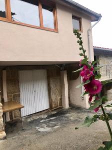 a house with a white door and a bench at Apartamento rural Meaus in Rubiás