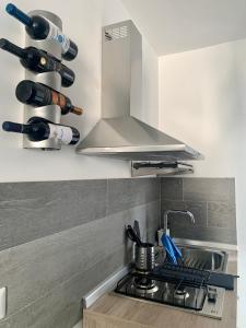una cocina con fogones y un montón de botellas de vino en Orto siculo house-1, en Catania