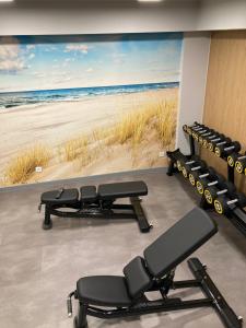 a gym with a large screen of the beach at Apartament K&K Klifowa Rewal in Rewal