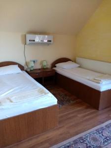 a room with two beds and a table at PENSIUNEA OANA in Balc