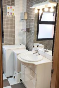 セゴビアにあるEl Balconcito de San Millanのバスルーム(洗面台、トイレ付)、窓が備わります。