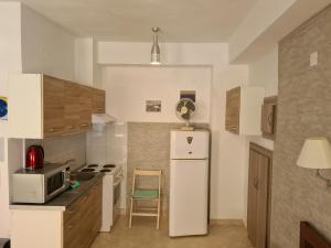 uma cozinha com um frigorífico e uma cadeira. em Abeas Samos Antonis 3 em Samos