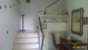 a staircase in a room with a mirror and a chair at Casa Giulia in Porto SantʼElpidio
