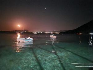 a white boat in the water at night at Abeas Samos Antonis 3 in Samos