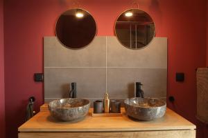 two sinks on a wooden counter with two mirrors at Seehaus Kärnten in Saager