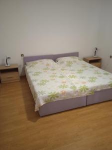 een bed in een slaapkamer met 2 nachtkastjes en 2 tafels bij Apartment Oswald in Crikvenica