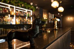 une statue d'un chien avec couronne assise sur un bar dans l'établissement The Chesterton Hotel, à Bicester