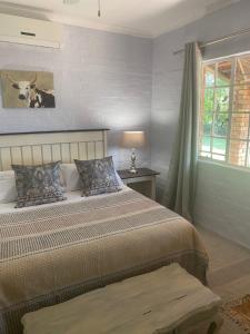 a bedroom with two beds and a window at Die Kothuis in Malelane