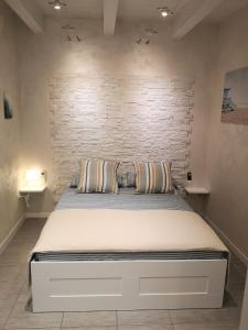 Bett in einem Zimmer mit Ziegelwand in der Unterkunft La Casetta del Marinaio in Fano