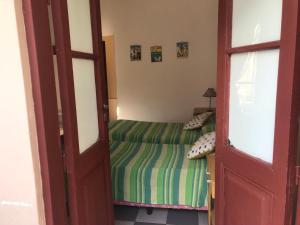 a small bedroom with a bed and a door at Posada Casa de Borgoña in Salta