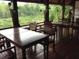 a room with wooden tables and chairs and a window at Lao Spirit Resort in Ban Xianglôm