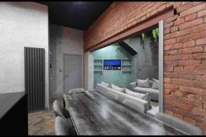 a living room with a couch and a brick wall at Casa Jungle Slps 20 Mcr Centre Hot tub, bar and cinema Room Leisure suite in Manchester