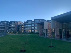 a building with a yard with trees in front of it at Condominio Costa Pucon in Pucón