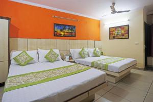 2 łóżka w pokoju z pomarańczowymi ścianami w obiekcie Hotel Sun Village Near New Delhi Railway Station w Nowym Delhi