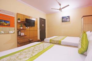 Cette chambre comprend 2 lits et une télévision à écran plat. dans l'établissement Hotel Sun Village Near New Delhi Railway Station, à New Delhi
