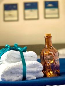 a stack of towels next to a glass bottle at Apartament Brisa in Pobierowo