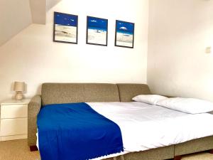 a bedroom with a bed with a blue blanket on it at Apartament Brisa in Pobierowo