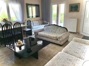 a living room with a couch and a coffee table at Jo Relax House in Nea Makri