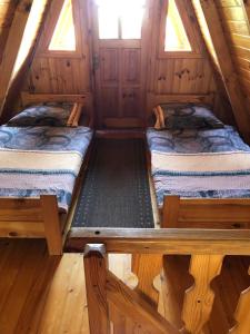 dwa łóżka w drewnianym domku z oknami w obiekcie "Domek na Wiejskiej 4" Polańczyk , 696-025-331 w Polańczyku