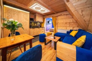 een woonkamer met een blauwe bank en een tafel bij Chałpa u Zbójnika in Zakopane