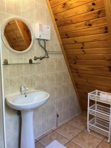 ein Bad mit einem Waschbecken und einem Spiegel in der Unterkunft "Domek na Wiejskiej 4" Polańczyk , 696-025-331 in Polańczyk