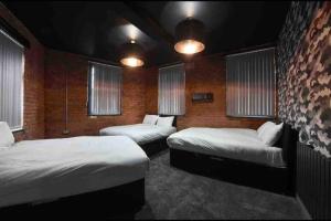 een kamer met 2 bedden en 2 ramen bij Casa Nomade Penthouse slps 20 people Mcr centre in Manchester