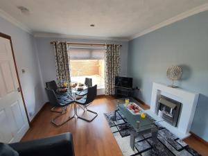 a living room with a table and a fireplace at PREMIER - Kenilworth House in Holytown