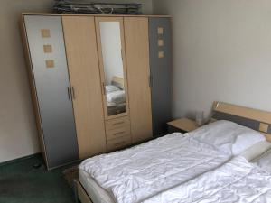 een slaapkamer met een bed, een dressoir en een spiegel bij Kapitänshaus Scharmberg, Ferienwohnung Seeadler in Born