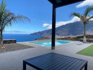 una piscina con vistas al océano y a las montañas en Casa La Picota, en Los Llanillos