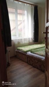 a bedroom with two beds in front of a window at pokoje STIFADO in Międzyzdroje