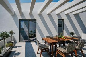 a wooden table and chairs on a patio at Origami Boutique Residences in Nafplio