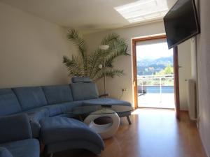 a living room with a blue couch and a tv at Alpin-Check-in in Reutte
