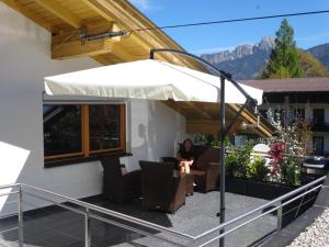 a person sitting in a chair under an umbrella on a patio at Alpin-Check-in in Reutte
