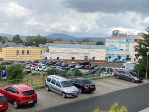a parking lot with cars parked in front of a building at Private Apartment Rozvadov in Rozvadov
