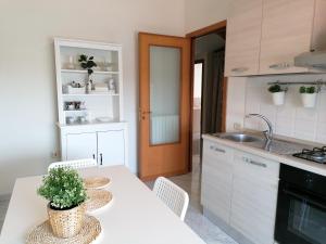 kuchnia ze stołem, krzesłami i zlewem w obiekcie Rara Domus B&B w mieście Pompeje