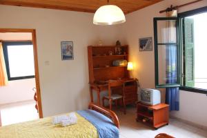 a bedroom with a bed and a desk and a television at Gianna's House in Stavros