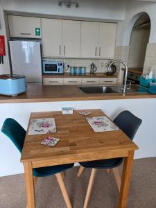 uma cozinha com uma mesa de madeira e um lavatório em Ocean View em Cawsand