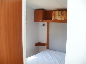 a small bedroom with a bunk bed and a closet at Camping les Silhols in Lagorce +14 photos