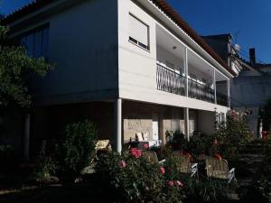 un edificio con sillas y flores delante de él en Casa do Vicente, en Tabuaço