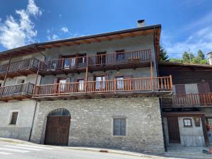 a building with wooden balconies on top of it at Frazione Duc Apartments in Sestriere