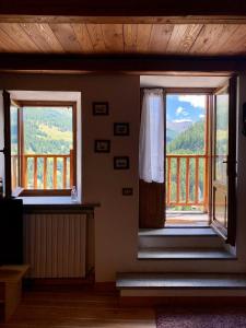 a room with two windows and a balcony at Frazione Duc Apartments in Sestriere
