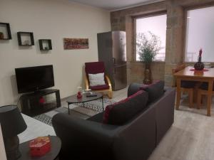 sala de estar con sofá y TV en Rustic House Fundão, en Fundão