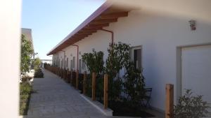 un bâtiment blanc avec une clôture à côté d'un trottoir dans l'établissement Rena Resort, à Mondragone