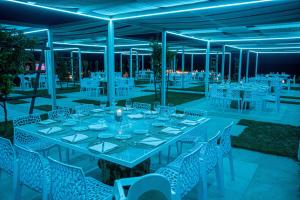 una mesa larga con mesas y sillas blancas en Rena Resort, en Mondragone