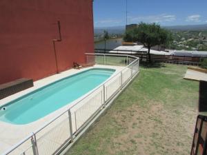 una piscina al lado de un edificio en La Villa Inn en Villa Carlos Paz