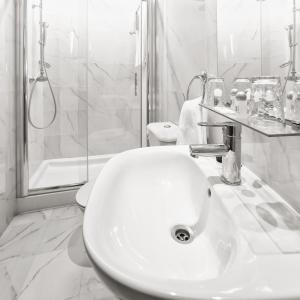 a white sink sitting in a bathroom next to a bath tub at Hotel Aliados in Porto