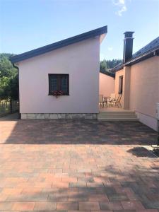 a white building with a patio in front of it at Apartman Lalica in Kolašin