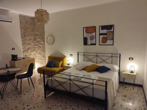 a bedroom with a bed and a table and chairs at L'OLIVA CONTESA - la BLU in Gaeta